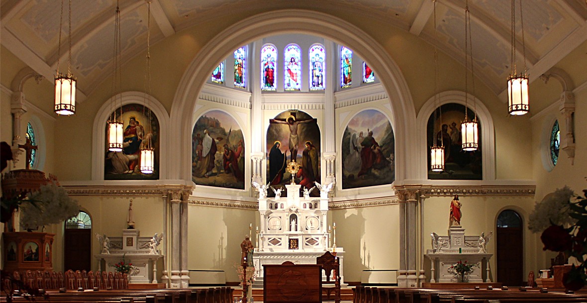 View of altar with triptych paintings and stained glass windows